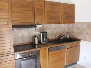 una pequeña cocina con armarios de madera y fregadero en Quaint Apartment in Reddelich, en Reddelich