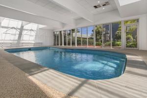 a large swimming pool in a building with blue water at Bellevue On The Lakes in Lakes Entrance
