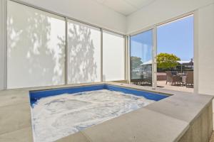 a hot tub in a room with large windows at Bellevue On The Lakes in Lakes Entrance