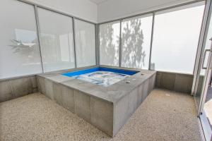 a hot tub in a room with large windows at Bellevue On The Lakes in Lakes Entrance