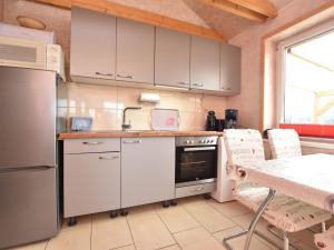 a kitchen with white cabinets and a table with chairs at Enchanting Holiday Home in Ruhn near the Sea in Rühn
