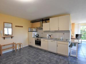 ティンメンドルフにあるModern apartment in Porec and 900 m from the beachの白いキャビネットとテーブル付きのキッチンが備わります。