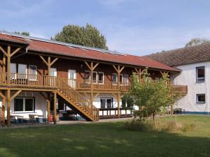 a large wooden building with a deck on it at Spacious Apartment in Boddin near Baltic Sea in Boddin