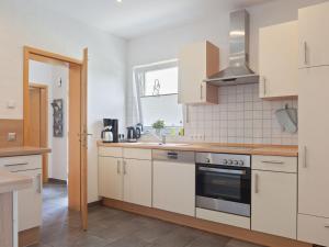 een keuken met witte kasten en een fornuis met oven bij Holiday home in Winterberg with sauna in Winterberg