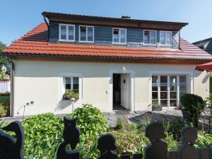 Uma casa com um gato preto à frente. em Comfortable holiday home in Saxony with terrace em Oederan