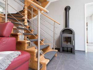 sala de estar con estufa de leña y escaleras en Comfortable holiday home in Saxony with terrace en Oederan