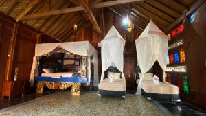 a bedroom with two beds with mosquito nets at Deepsky Villa in Karimunjawa
