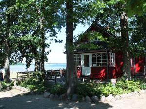 a red and white house in the trees at Gemuetliches Ferienhaus in Zierow mit Sauna in Zierow