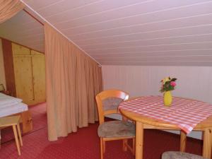 SchirgiswaldeにあるPleasant Holiday Home With Terrace in Schirgiswalde Germanyのテーブル、椅子、ベッドが備わる客室です。