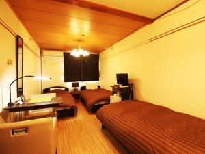a hotel room with two beds and a desk at Daigo House in Daigo