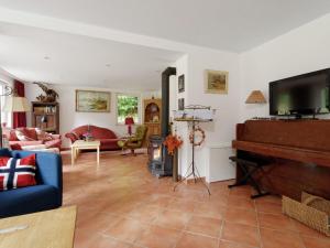 uma sala de estar com televisão e piano em Upscale holiday home in Bad Stuer with terrace and garden em Stuer