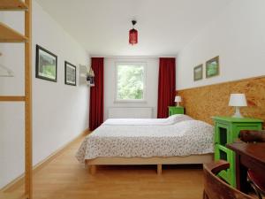 StuerにあるUpscale holiday home in Bad Stuer with terrace and gardenのベッドルーム1室(赤いカーテンと窓付きのベッド1台付)