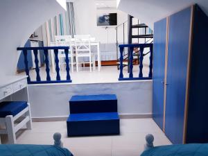 una sala de estar con paredes y escaleras azules y blancas en White & Blue en Perivolos