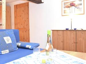 a table with a blue couch and a bottle and glasses at Small apartment in Hesse with terrace and garden in Frielendorf