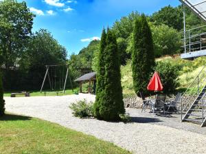 um parque com uma árvore, uma mesa e um guarda-chuva em Apartment with terrace in H ddingen em Bad Wildungen