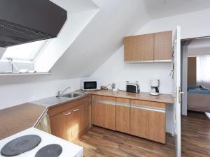 a kitchen with wooden cabinets and a sink at Apartment in health and Kneipp resort in the Upper Harz with huge garden in Wildemann
