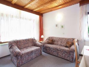 a living room with a couch and a chair at Apartment in Armsfeld with heated outdoor pool in Bergfreiheit