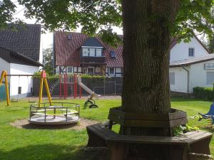 un parque con un árbol y un parque infantil en Apartment in Ober Waroldern mit Sauna, en Oberwaroldern