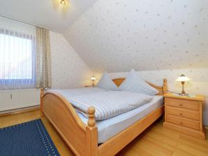 ein Schlafzimmer mit einem Holzbett und einem Fenster in der Unterkunft Apartment in Eimelrod with Panoramic Views in Willingen