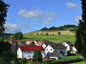 ein Dorf mit weißen Häusern und grünen Hügeln in der Unterkunft Apartment in Eimelrod with Panoramic Views in Willingen