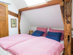 a bedroom with a bed with red and blue pillows at Schleiden Timber-Frame Retreat in Schleiden