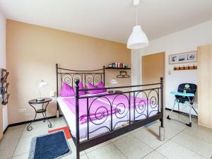 Schlafzimmer mit einem Bett mit rosa Tagesdecke in der Unterkunft Dog friendly holiday home in Hesse with garden in Bad Zwesten