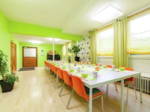 een grote conferentiezaal met een lange tafel en oranje stoelen bij Dog friendly holiday home in Hesse with garden in Bad Zwesten