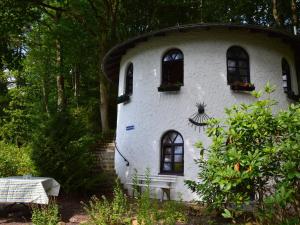 een rond huis met ramen en bloemen erop bij Cosy Holiday Home in Strotzb sch with Sauna in Strotzbüsch