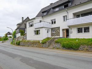 a white house on the side of a street at Well kept holiday home with terrace in Winterberg