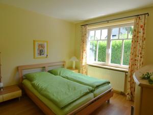 MadfeldにあるTasteful apartment near Brilon on the ground floor with terrace and gardenのベッドルーム(緑のベッド1台、窓付)