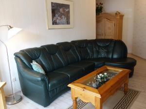 a black leather couch in a living room with a coffee table at Apartment with private terrace in Runkel in Ennerich