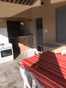 a patio with a table and chairs and a stove at CHAMBRES D'HÔTES CLIMATISÉES avec CUISINE d'ÉTÉ "VILLA GOUR du PEYROL" in Buisson