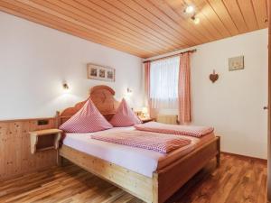 a bedroom with a wooden bed with pink pillows at Apartment in Ruhpolding with Alps view in Ruhpolding