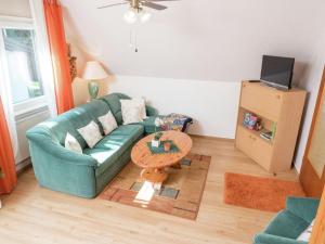 a living room with a green couch and a table at Cheerful apartment near city centre of Haslach in Haslach im Kinzigtal