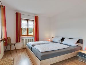 a bedroom with two beds and a window with red curtains at Apartment on the edge of the forest in Kleines Wiesental