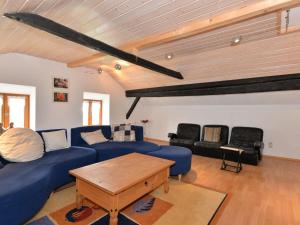 a living room with a blue couch and a table at Former farmhouse with sunbathing lawn in Zenting