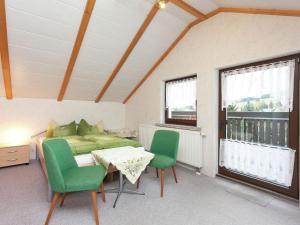 1 dormitorio con 1 cama, mesa y sillas en Appealing holiday home in Altenfeld with terrace en Altenfeld