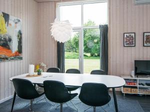 a dining room with a white table and chairs at 8 person holiday home in Glesborg in Fjellerup Strand