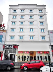 ein großes weißes Gebäude mit davor geparkt in der Unterkunft Hotel Osaka Airport in Istanbul