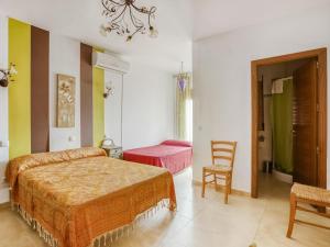 - une chambre avec deux lits et une chaise dans l'établissement Belvilla by OYO Casa La Espartera, à Ciudad Real
