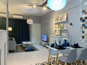 uma sala de estar com uma mesa e cadeiras e uma televisão em Maya Homestay Putrajaya Unit Dua em Putrajaya
