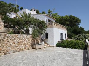 een huis met een stenen muur en een stenen oprit bij Belvilla by OYO Ratjada in Font de Sa Cala