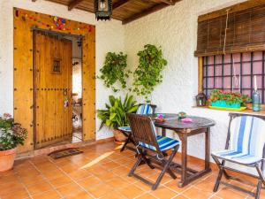 ZagrillaにあるVibrant Holiday Home in Priego de C rdoba with Private Poolのパティオ(テーブル、椅子、ドア付)