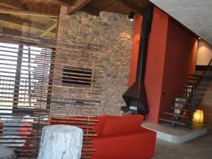 a living room with a red couch and a stone wall at Belvilla by OYO Cobert de l Era in Oden