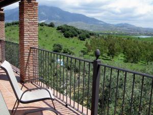 a balcony with a bench and a view of a field at Belvilla by OYO Casas Rurales Huetor in Viñuela