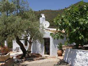 una casa blanca con árboles delante de ella en Belvilla by OYO Cortijo Ricardo en Acebuchal