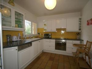 a kitchen with white cabinets and a sink at Spacious villa with garden near Grasse in Mouans-Sartoux