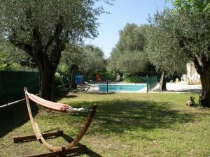 a hammock sitting in the grass next to a pool at Spacious villa with garden near Grasse in Mouans-Sartoux