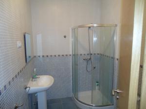 a bathroom with a glass shower and a sink at Apartamentos San Guillermo in Finisterre