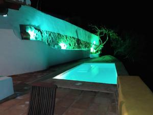 a swimming pool at night with lights on the wall at Belvilla by OYO La Zamarra in Alcaucín